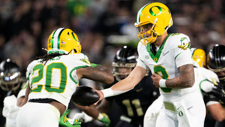 Oct 18, 2024; West Lafayette, Indiana, USA; Oregon Ducks quarterback Dillon Gabriel (8) hands the ball off to Oregon Ducks quarterback Luke Moga (10) during the game against the Purdue Boilermakers at Ross-Ade Stadium. Mandatory Credit: Marc Lebryk-Imagn Images