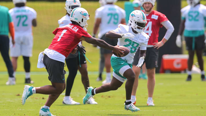 Miami Dolphins quarterback Tua Tagovailoa (1) handoffs the football to running back De'Von Achane (28) during mandatory minicamp at Hard Rock Stadium this June.