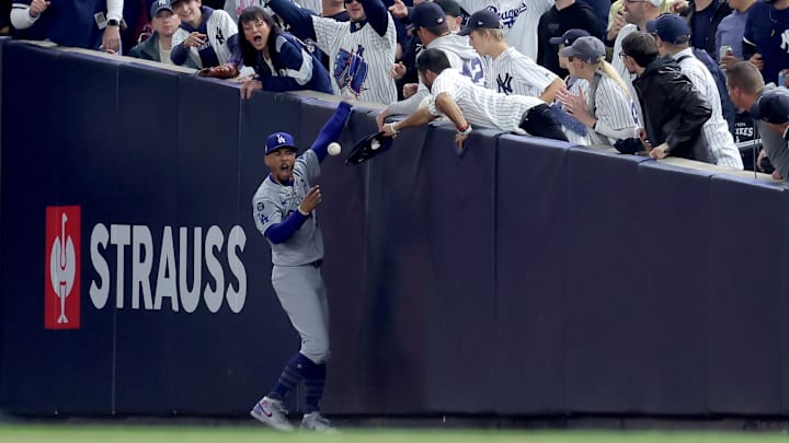 Oct 29, 2024; New York, New York, USA; Los Angeles Dodgers shortstop Mookie Betts (50) makes a catch in foul territory as a New York Yankees fan interferes during the first inning in game four of the 2024 MLB World Series at Yankee Stadium. Mandatory Credit: Brad Penner-Imagn Images