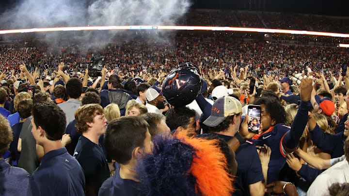 Sep 26, 2025; Charlottesville, Virginia, USA; Virginia Cavaliers players and fans celebrate on the field after the Cavaliers' win over the Florida State Seminoles in two overtimes at Scott Stadium. Mandatory Credit: Geoff Burke-Imagn Images