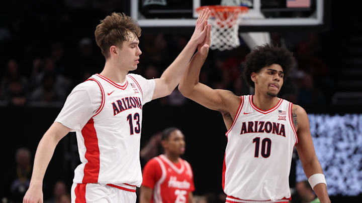 Mar 14, 2026; Kansas City, MO, USA; Arizona Wildcats center Motiejus Krivas (13) and forward Koa Peat (10) high-five during the second half against the Houston Cougars during the men's Big 12 Conference Tournament Championship at T-Mobile Center. Mandatory Credit: William Purnell-Imagn Images