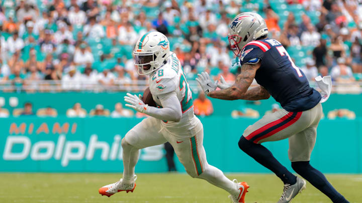 Miami Dolphins running back De'Von Achane (28) runs with the football against New England Patriots cornerback Carlton Davis III (7) during the third quarter at Hard Rock Stadium in Week 2.