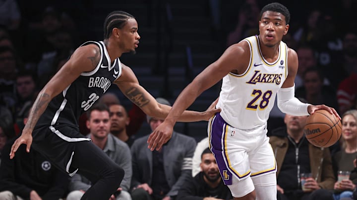 Mar 31, 2024; Brooklyn, New York, USA; Los Angeles Lakers forward Rui Hachimura (28) dribbles against Brooklyn Nets center Nic Claxton (33) during the first half at Barclays Center. Mandatory Credit: Vincent Carchietta-Imagn Images