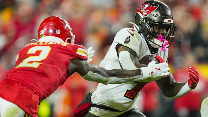 Nov 4, 2024; Kansas City, Missouri, USA; Tampa Bay Buccaneers running back Bucky Irving (7) runs the ball against Kansas City Chiefs cornerback Joshua Williams (2) during the second half at GEHA Field at Arrowhead Stadium. Mandatory Credit: Jay Biggerstaff-Imagn Images