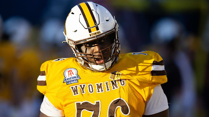Dec 30, 2022; Tucson, AZ, USA; Wyoming Cowboys guard Emmanuel Pregnon (76) against the Ohio Bobcats during the 2022 Barstool Sports Arizona Bowl at Arizona Stadium. Mandatory Credit: Mark J. Rebilas-Imagn Images