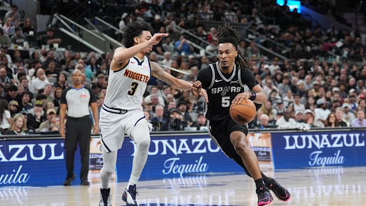 Mar 12, 2026; San Antonio, Texas, USA;  San Antonio Spurs guard Stephon Castle (5) dribbles against Denver Nuggets guard Julian Strawther (3) in the second half at Frost Bank Center. Mandatory Credit: Daniel Dunn-Imagn Images