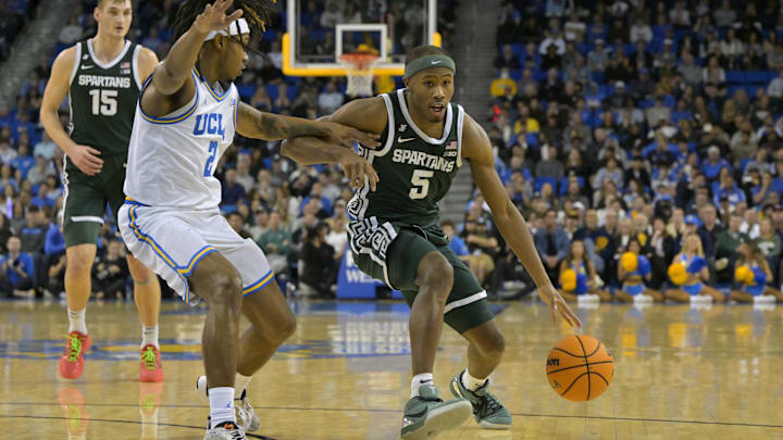 Feb 4, 2025; Los Angeles, California, USA; Michigan State Spartans guard Tre Holloman (5) drives past UCLA Bruins guard Dylan Andrews (2) in the second half at Pauley Pavilion presented by Wescom. Mandatory Credit: Jayne Kamin-Oncea-Imagn Images