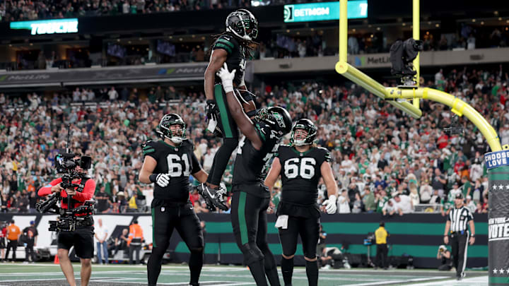 Oct 31, 2024; East Rutherford, New Jersey, USA; New York Jets wide receiver Davante Adams (17) celebrates his touchdown against the Houston Texans with offensive tackles Olu Fashanu (74) and Max Mitchell (61) and center Joe Tippmann (66) during the fourth quarter at MetLife Stadium. 