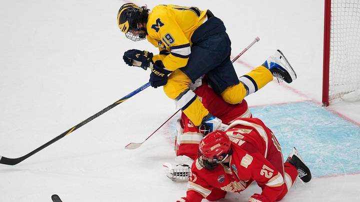 Apr 9, 2026; Las Vegas, Nevada, UNITED STATES; Michigan Wolverines forward Michael Hage (19) collides with Denver Pioneers goalie Johnny Hicks (31) in the second period in the semifinals of the NCAA men's ice hockey Frozen Four at T-Mobile Arena. Mandatory Credit: Lucas Peltier-Imagn Images