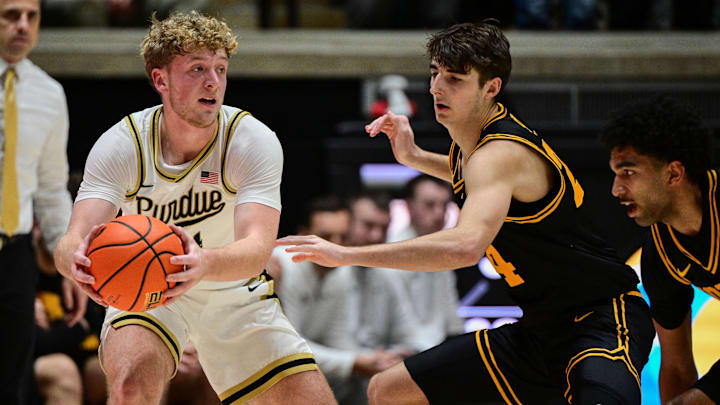 Purdue Boilermakers guard Jack Benter (14) looks to pass against Iowa Hawkeyes guard Tate Sage (24). Purdue Boilermakers guard Jack Benter (14) looks to pass against Iowa Hawkeyes guard Tate Sage (24).