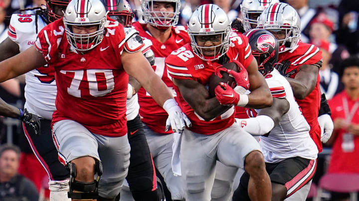 Sep 16, 2023; Columbus, Ohio, USA; Ohio State Buckeyes running back TreVeyon Henderson (32) gets a block from offensive lineman Josh Fryar (70) during the second half of the NCAA football game against the Western Kentucky Hilltoppers at Ohio Stadium. Ohio State won 63-10. Sep 16, 2023; Columbus, Ohio, USA; Ohio State Buckeyes running back TreVeyon Henderson (32) gets a block from offensive lineman Josh Fryar (70) during the second half of the NCAA football game against the Western Kentucky Hilltoppers at Ohio Stadium. Ohio State won 63-10.