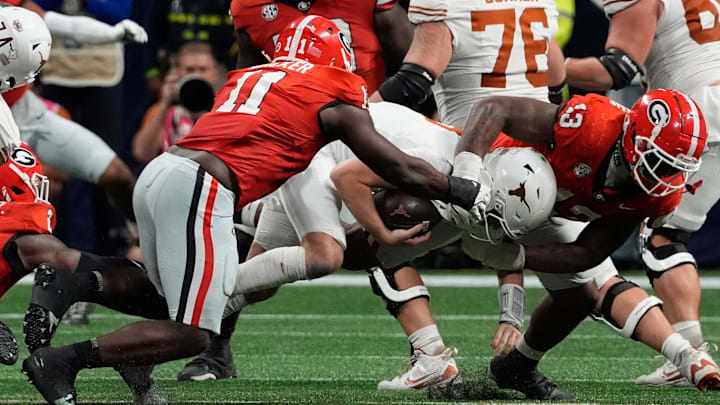 Georgia Bulldog defenders Jalon Walker (11) and Mykel Williams (13) take down Texas Longhorns quarterback Quinn Ewers (3)