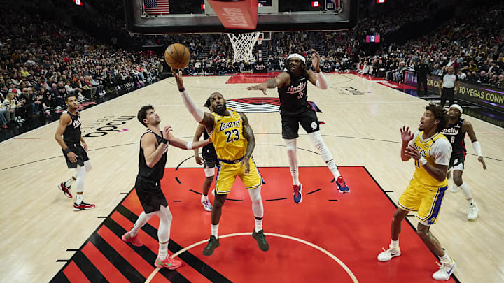 Feb 20, 2025; Portland, Oregon, USA; Los Angeles Lakers forward LeBron James (23) scores a basket during the first half against Portland Trail Blazers forward Deni Avdija (8) and center Robert Williams III (35) at Moda Center. Mandatory Credit: Troy Wayrynen-Imagn Images Feb 20, 2025; Portland, Oregon, USA; Los Angeles Lakers forward LeBron James (23) scores a basket during the first half against Portland Trail Blazers forward Deni Avdija (8) and center Robert Williams III (35) at Moda Center. Mandatory Credit: Troy Wayrynen-Imagn Images