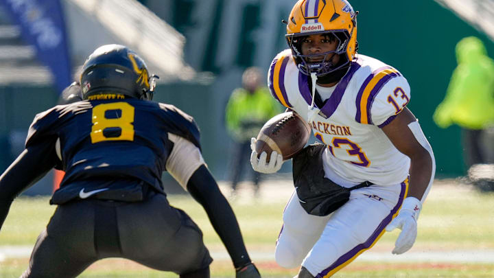 Dec 6, 2024; Birmingham, AL, USA; Jackson's Ezavier Crowell (13) tries to evade a tackle by Cherokee County's Tyson Wood (8) at Protective Stadium in the AHSAA 4A State Championship game.
