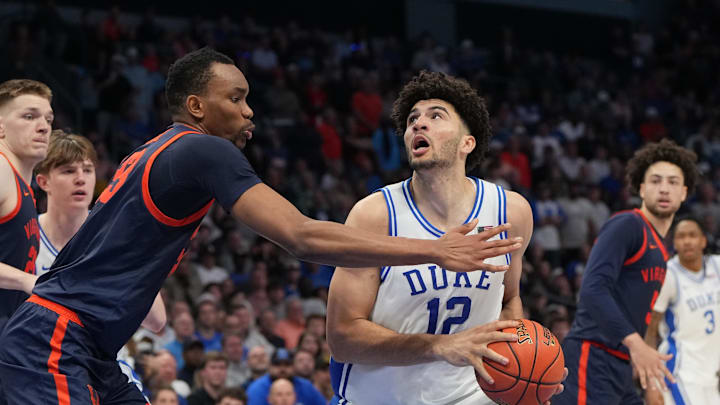 Mar 14, 2026; Charlotte, NC, USA; Duke Blue Devils forward Cameron Boozer (12) withj the ball as Virginia Cavaliers center Ugonna Onyenso (33) defends in the second half during the men's ACC Conference Tournament Championship at Spectrum Center. Mandatory Credit: Bob Donnan-Imagn Images
