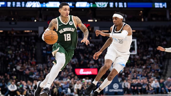 Feb 12, 2025; Minneapolis, Minnesota, USA; Milwaukee Bucks forward Kyle Kuzma (18) dribbles against Minnesota Timberwolves forward Jaden McDaniels (3) in the fourth quarter at Target Center. Mandatory Credit: Brad Rempel-Imagn Images