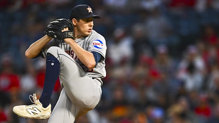 Blubaugh throws a pitch in agrey unifor