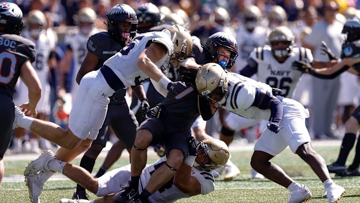 Oct 5, 2024; Colorado Springs, Colorado, USA; Air Force Falcons defensive end Jack Curtis (10) is tackled by Navy Midshipmen linebacker Colin Ramos (44) and defensive end Luke Pirris (35) and linebacker Mbiti Williams Jr. (7) in the fourth quarter at Falcon Stadium. M