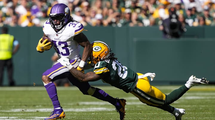 Sep 29, 2024; Green Bay, Wisconsin, USA;  Minnesota Vikings running back Aaron Jones (33) rushes with the football as Green Bay Packers safety Javon Bullard (20) defends during the third quarter at Lambeau Field.