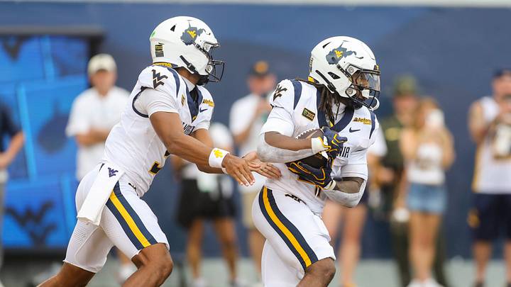 Sep 5, 2026; Morgantown, West Virginia, USA; West Virginia Mountaineers quarterback Michael Hawkins Jr. (3) hands the ball off to West Virginia Mountaineers running back Cam Cook (4) during the first quarter against the Coastal Carolina Chanticleers at Milan Puskar Stadium. Mandatory Credit: Ben Queen-Imagn Images Sep 5, 2026; Morgantown, West Virginia, USA; West Virginia Mountaineers quarterback Michael Hawkins Jr. (3) hands the ball off to West Virginia Mountaineers running back Cam Cook (4) during the first quarter against the Coastal Carolina Chanticleers at Milan Puskar Stadium. Mandatory Credit: Ben Queen-Imagn Images
