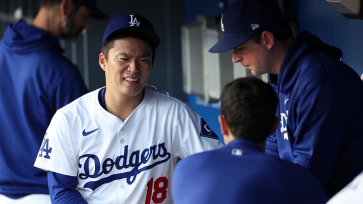 Jun 1, 2024; Los Angeles, California, USA;  Los Angeles Dodgers starting pitcher Yoshinobu Yamamoto (18) talks to interpreter Will Ireton in the dugout during the first inning against the Colorado Rockies at Dodger Stadium. Mandatory Credit: Kiyoshi Mio-USA TODAY Sports