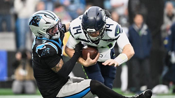 Dec 28, 2025; Charlotte, North Carolina, USA; Carolina Panthers safety Tre'von Moehrig (7) sacks Seattle Seahawks quarterback Sam Darnold (14) for a ten-yard loss during the first quarter at Bank of America Stadium. Mandatory Credit: Bob Donnan-Imagn Images