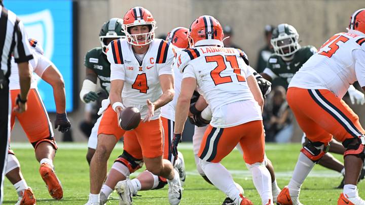 Oct 10, 2026; East Lansing, Michigan, USA;  Illinois Fighting Illini quarterback Katin Houser (4) pitches the ball to Illinois Fighting Illini running back Aidan Laughery (21) during the first quarter at Spartan Stadium.  Mandatory Credit: Dale Young-Imagn Images
