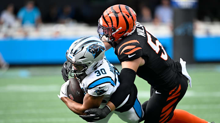 Sep 29, 2024; Charlotte, North Carolina, USA;  Carolina Panthers running back Chuba Hubbard (30) has the ball as Cincinnati Bengals linebacker Logan Wilson (55) attempts a tackle in the fourth quarter at Bank of America Stadium. Mandatory Credit: Bob Donnan-Imagn Images