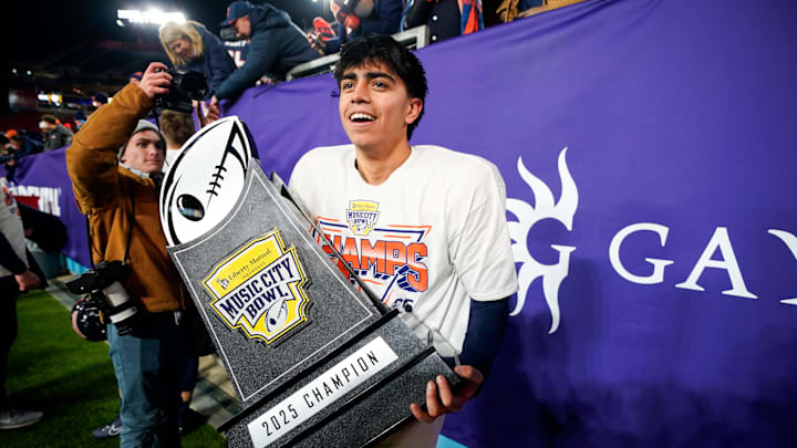 Illinois kicker David Olano (24) carries the Music City Bowl trophy after his field goal secured the win over Tennessee in an NCAA college football game on Dec. 30, 2025, in Nashville, Tennessee.