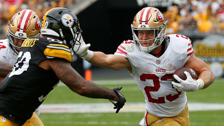 San Francisco 49ers running back Christian McCaffrey (R) stiff-arms Pittsburgh Steelers defender Elandon Roberts (L)