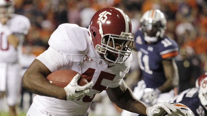 Nov 26, 2011; Auburn, AL, USA; Alabama Crimson Tide running back Jalston Fowler (45) pushes Auburn Tigers linebacker Jawara White (38) out of the way and scores a touchdown in the fourth quarter at Jordan-Hare Stadium.  The Crimson Tide beat the Tigers 42-14.  