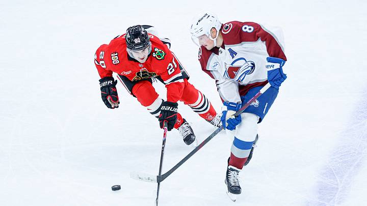 Nov 23, 2025; Chicago, Illinois, USA; Chicago Blackhawks center Ryan Greene (20) battles for the puck with Colorado Avalanche defenseman Cale Makar (8) during the second period at United Center. Mandatory Credit: Kamil Krzaczynski-Imagn Images