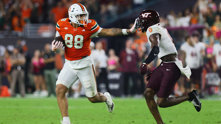 Sep 27, 2024; Miami Gardens, Florida, USA; Miami Hurricanes tight end Riley Williams (88) stiff arms Virginia Tech Hokies linebacker Keli Lawson (0) during the fourth quarter at Hard Rock Stadium. Mandatory Credit: Sam Navarro-Imagn Images