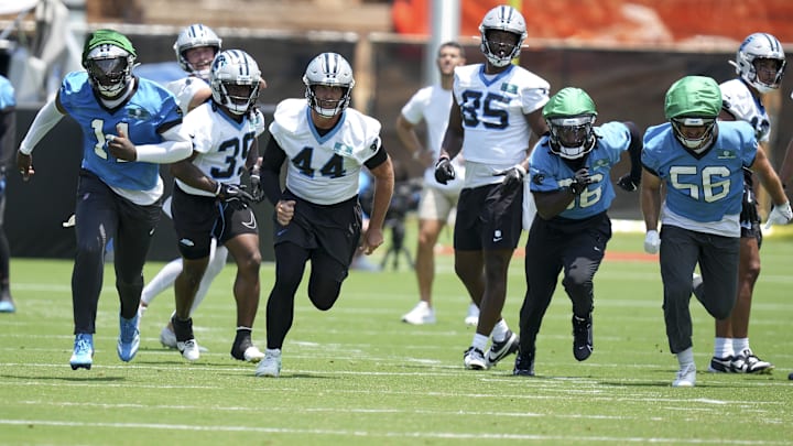 Carolina Panthers LB Nic Scourton, CB Mike Reid, LS JJ Jansen, TE James Mitchell, S Demani Richardson, and LB Christian Rozeboom hustle to the ball during minicamp.
