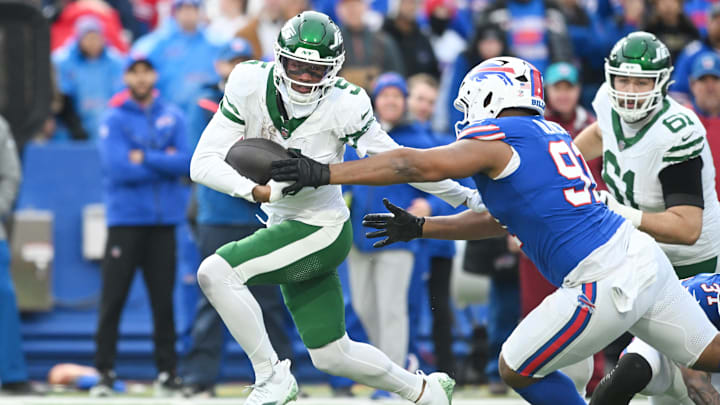 Dec 29, 2024; Orchard Park, New York, USA; New York Jets wide receiver Garrett Wilson (5) tries to avoid Buffalo Bills defensive tackle Ed Oliver (91) after making a catch in the third quarter at Highmark Stadium. 