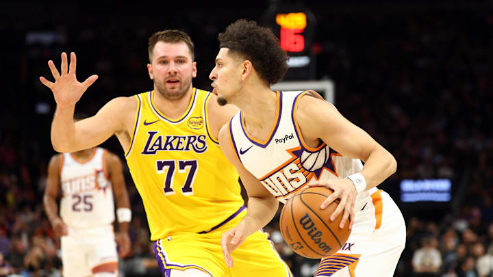 Oct 14, 2025; Phoenix, Arizona, USA; Phoenix Suns guard Koby Brea (14) drives to the basket against Los Angeles Lakers guard Luka Doncic (77) during an NBA preseason game at Mortgage Matchup Center. Mandatory Credit: Mark J. Rebilas-Imagn Images
