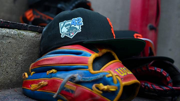 Apr 15, 2026; Cincinnati, Ohio, USA;  The Jackie Robinson patch is seen on a San Francisco Giants game hat, resting on the dugout steps, during the game against the Cincinnati Reds in the first inning at Great American Ball Park. Players and coaches will wear No. 42 in honor of Jackie Robinson Day around the league. Mandatory Credit: Aaron Doster-Imagn Images