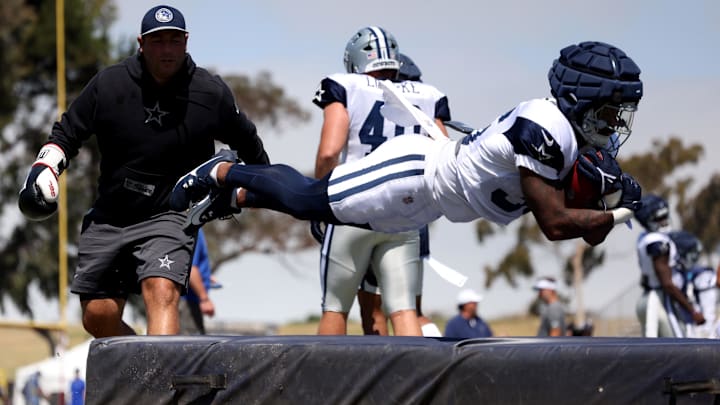 Dallas Cowboys running back Nathaniel Peat jumps on a pad during training camp.