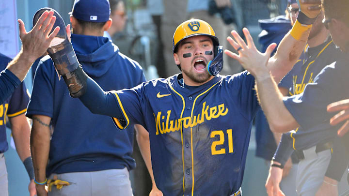 Oct 16, 2025; Los Angeles, California, USA; Milwaukee Brewers third baseman Caleb Durbin (21) celebrates in the dugout after scoring against the Los Angeles Dodgers in the second inning during game three of the NLCS round for the 2025 MLB playoffs at Dodger Stadium. Mandatory Credit: Jayne Kamin-Oncea-Imagn Images