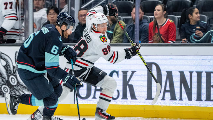 Nov 14, 2024; Seattle, Washington, USA;  Chicago Blackhawks forward Connor Bedard (98) skates against Seattle Kraken defenseman Adam Larsson (6) during the second period at Climate Pledge Arena. Mandatory Credit: Stephen Brashear-Imagn Images Nov 14, 2024; Seattle, Washington, USA;  Chicago Blackhawks forward Connor Bedard (98) skates against Seattle Kraken defenseman Adam Larsson (6) during the second period at Climate Pledge Arena. Mandatory Credit: Stephen Brashear-Imagn Images
