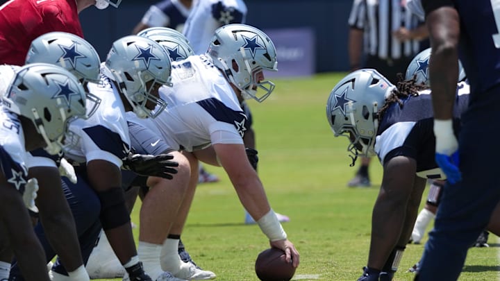 A general view of helmets at the line of scrimmage as Dallas Cowboys center Cooper Beebe snaps the ball at training camp 