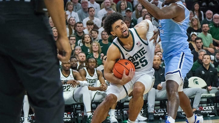 Michigan State freshman Malik Hall (25) drives and is fouled by Indiana State's Xavier Bledson (0)