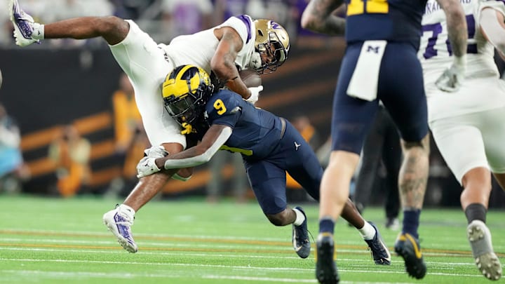 Washington wide receiver Ja'Lynn Polk is tackled by Michigan defensive back Rod Moore during the second half of the College Football Playoff national championship game against Washington at NRG Stadium in Houston, Texas on Monday, Jan. 8, 2024.