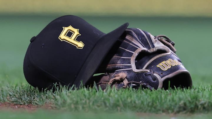 Sep 16, 2025; Pittsburgh, Pennsylvania, USA; A hat and glove belonging to Pittsburgh Pirates third baseman Jared Triolo (not pictured) on the field against the Chicago Cubs during the sixth inning at PNC Park. Mandatory Credit: Charles LeClaire-Imagn Images