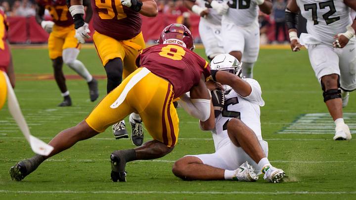 Oregon quarterback Dante Moore is hit after sliding by USC linebacker Desman Stephens II