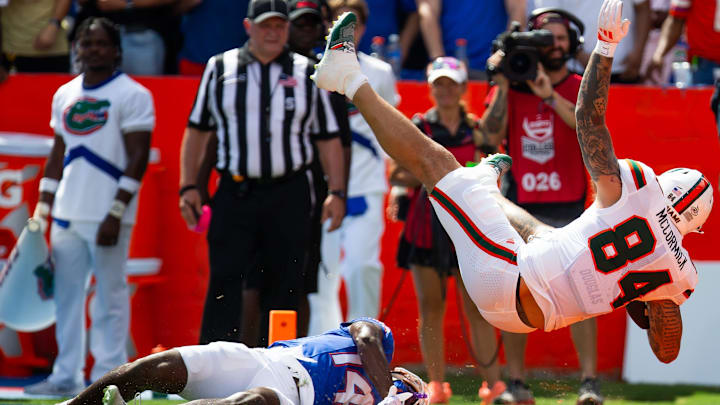 Florida Gators defensive back Jordan Castell (14) upends Miami Hurricanes tight end Cam McCormick (84) as he scores a touchdown during the season opener at Ben Hill Griffin Stadium in Gainesville, FL on Saturday, August 31, 2024 against the University of Miami Hurricanes in the first half. [Doug Engle/Gainesville Sun]
