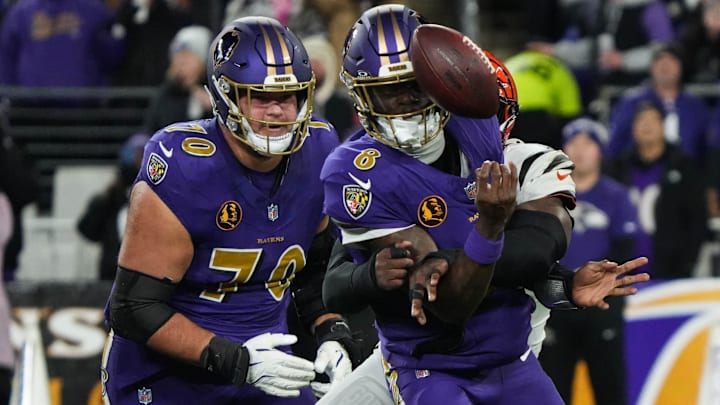 Bengals Joseph Ossai (58) helps take down Ravens Lamar Jackson (8) for the Bengals to take the ball during their game against the Ravens at M&T Bank Stadium on Thanksgiving Thursday November 27, 2025.