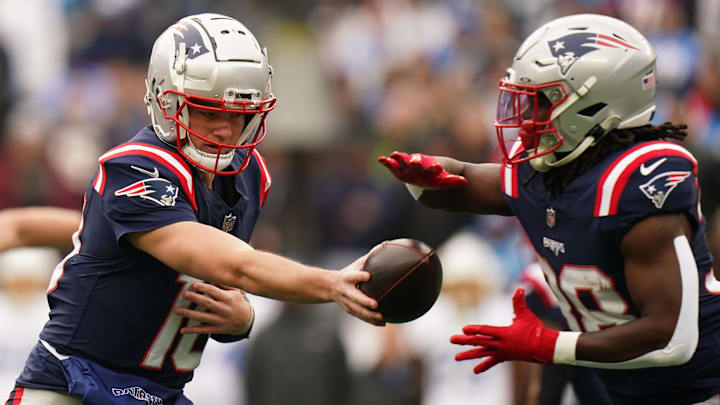 Dec 28, 2024; Foxborough, Massachusetts, USA; New England Patriots quarterback Drake Maye (10) hands off the ball to running back Rhamondre Stevenson (38) against the Los Angeles Chargers in the first quarter at Gillette Stadium. Mandatory Credit: David Butler II-Imagn Images