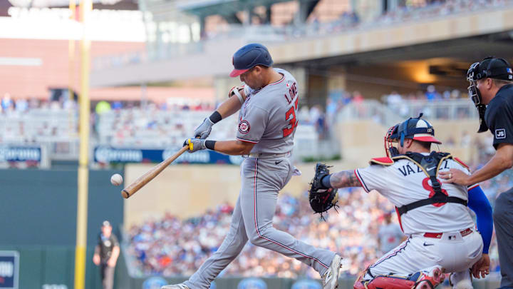 Jul 26, 2025; Minneapolis, Minnesota, USA; Washington Nationals first baseman Nathaniel Lowe (33) connects with the ball in the first inning. Minnesota Twins shortstop Carlos Correa (4) would field the ball and throw him out at first at Target Field. Mandatory Credit: Matt Blewett-Imagn Images