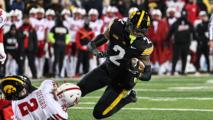 Nov 29, 2024; Iowa City, Iowa, USA; Iowa Hawkeyes running back Kaleb Johnson (2) runs the ball as Nebraska Cornhuskers defensive back Isaac Gifford (2) makes the tackle during the third quarter at Kinnick Stadium. Mandatory Credit: Jeffrey Becker-Imagn Images